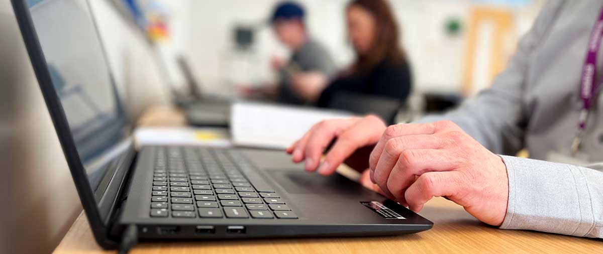 Close-up of a person typing on a computer keyboard
